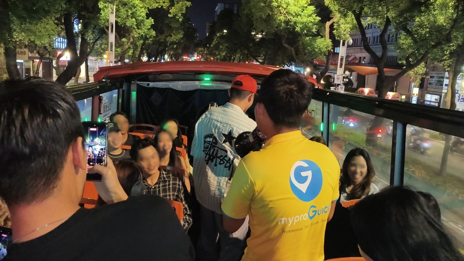 MyProGuide tour guide leading happy travelers on the TipsyBuzz double-decker bus tour in Taipei