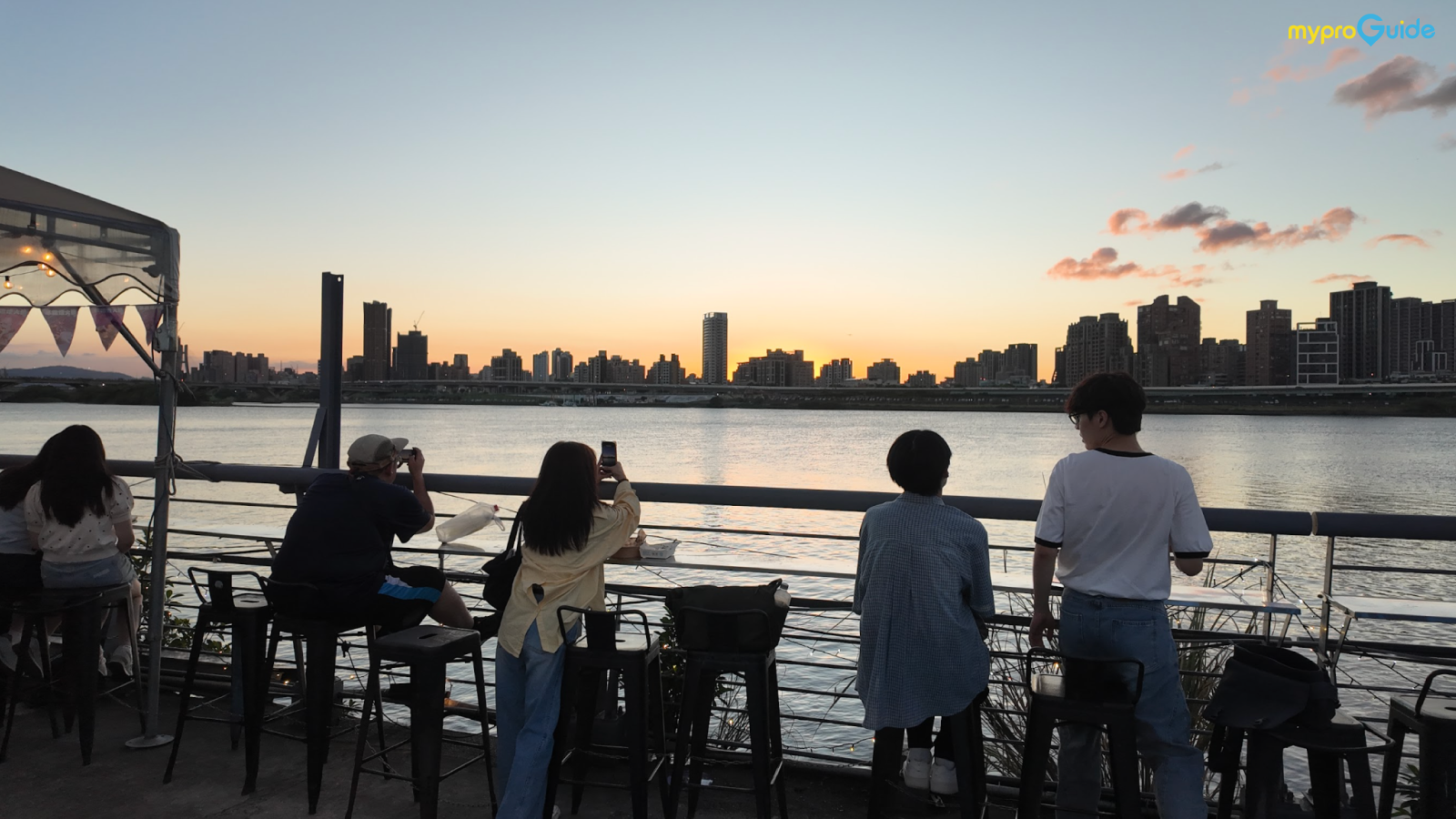 People enjoying the beautiful riverside scenery in Dadaocheng.