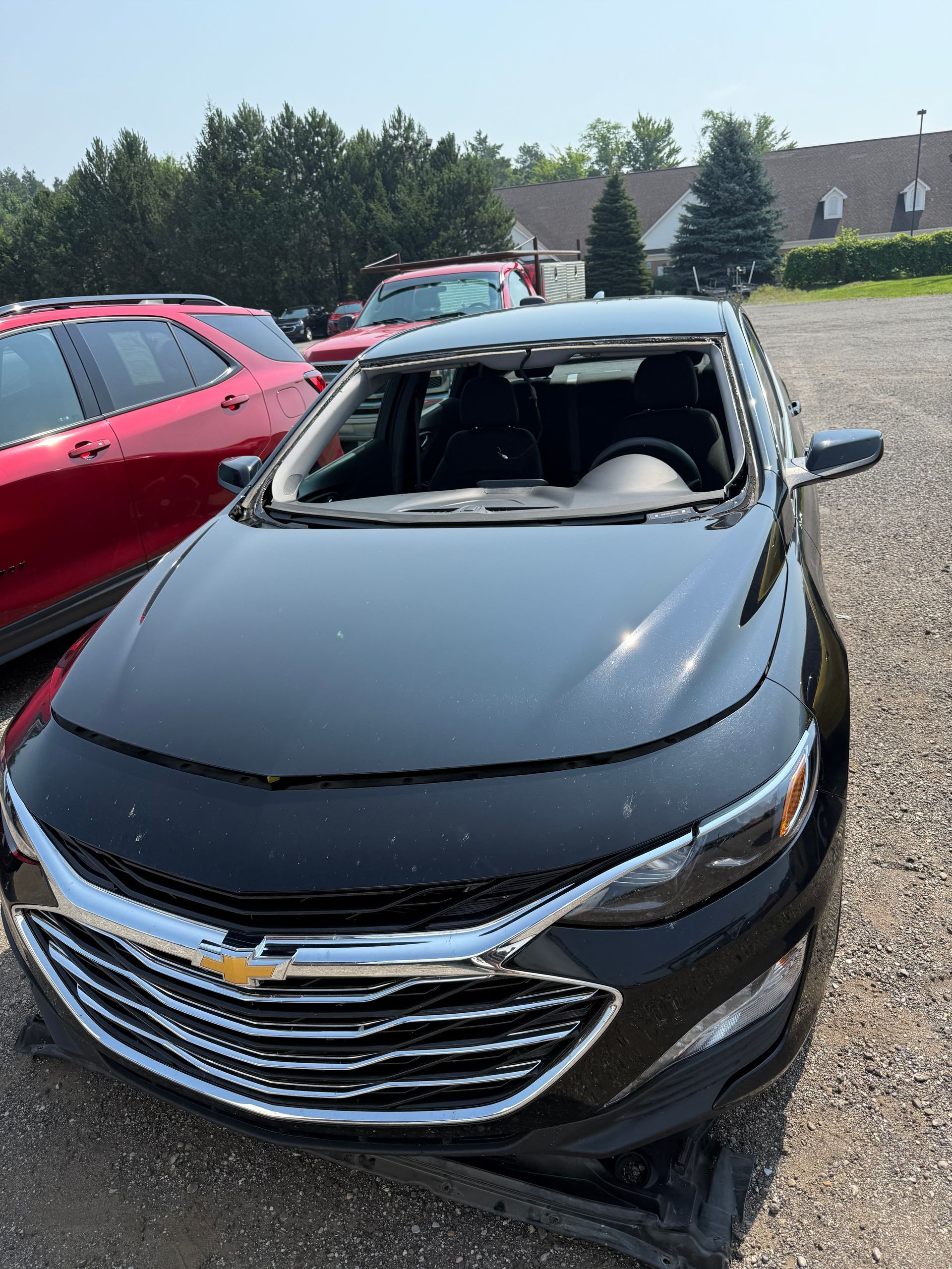 Broken car rear window with shattered glass on the seat and trunk area