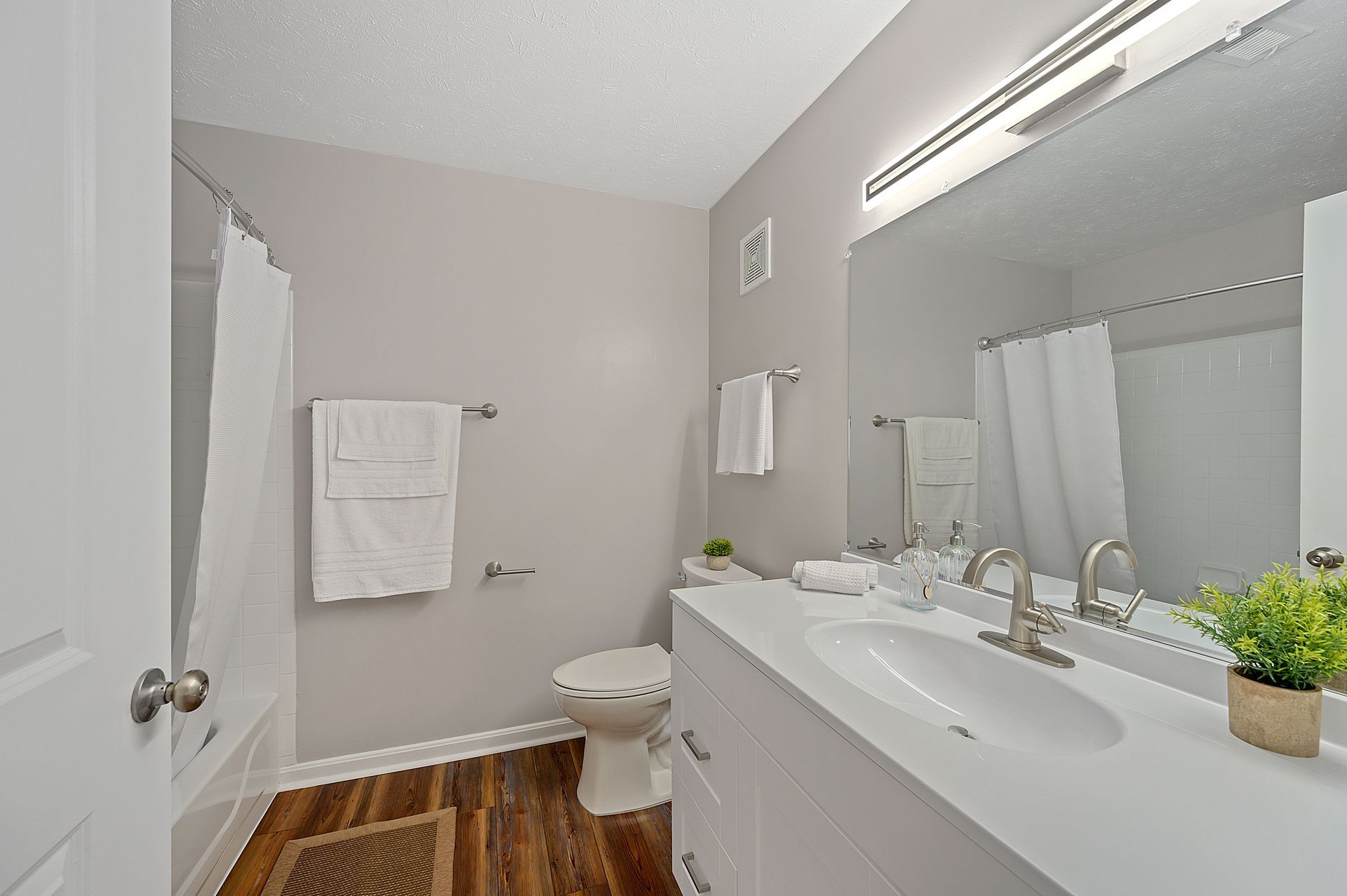 a bathroom with a toilet , sink , and mirror .