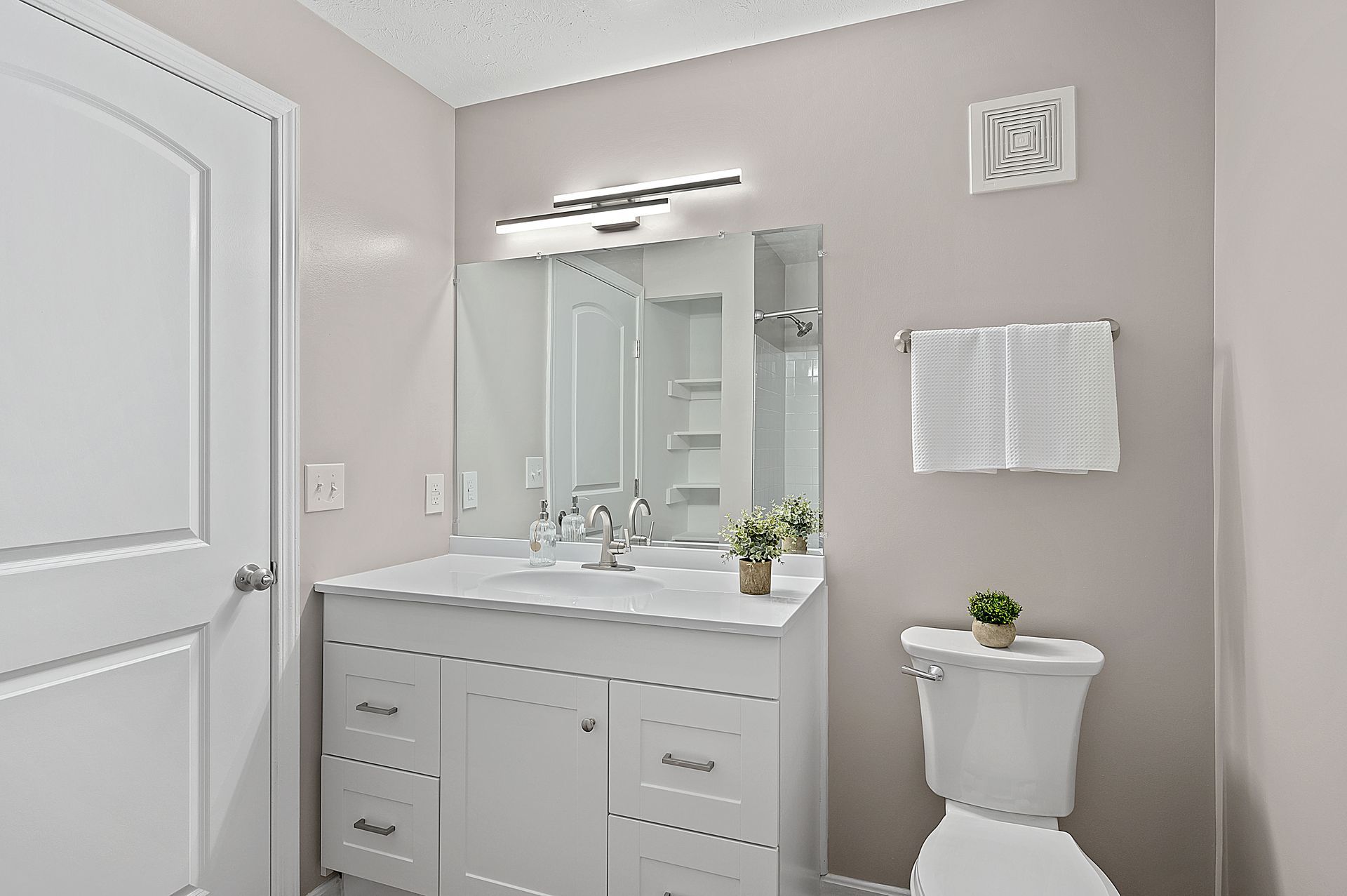 a bathroom with a sink , toilet and mirror .