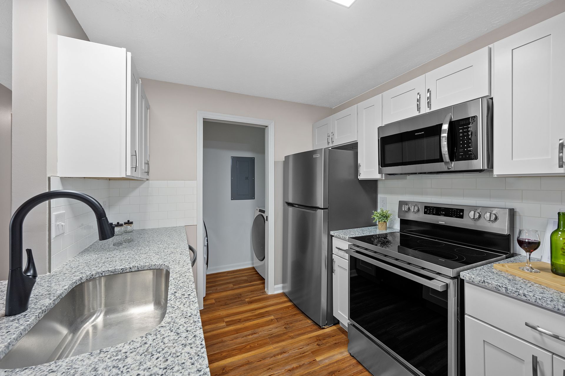 Modern apartment kitchen with stainless steel appliances and white cabinets