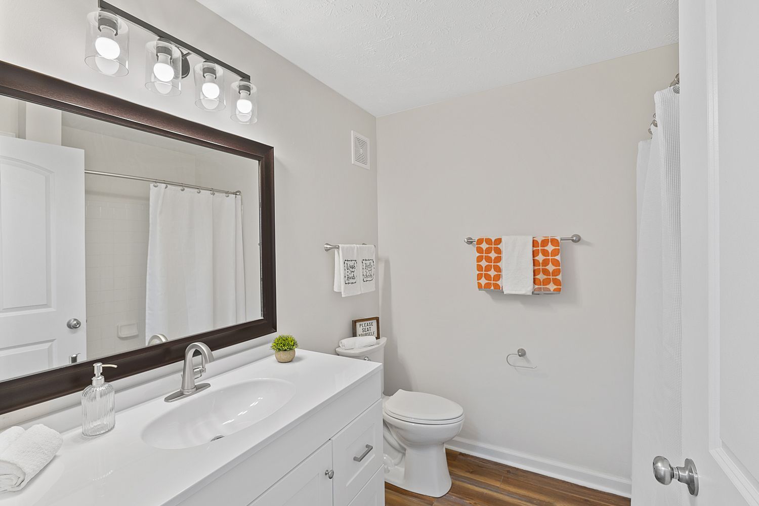 Modern apartment bathroom with large mirror, sink, and shower