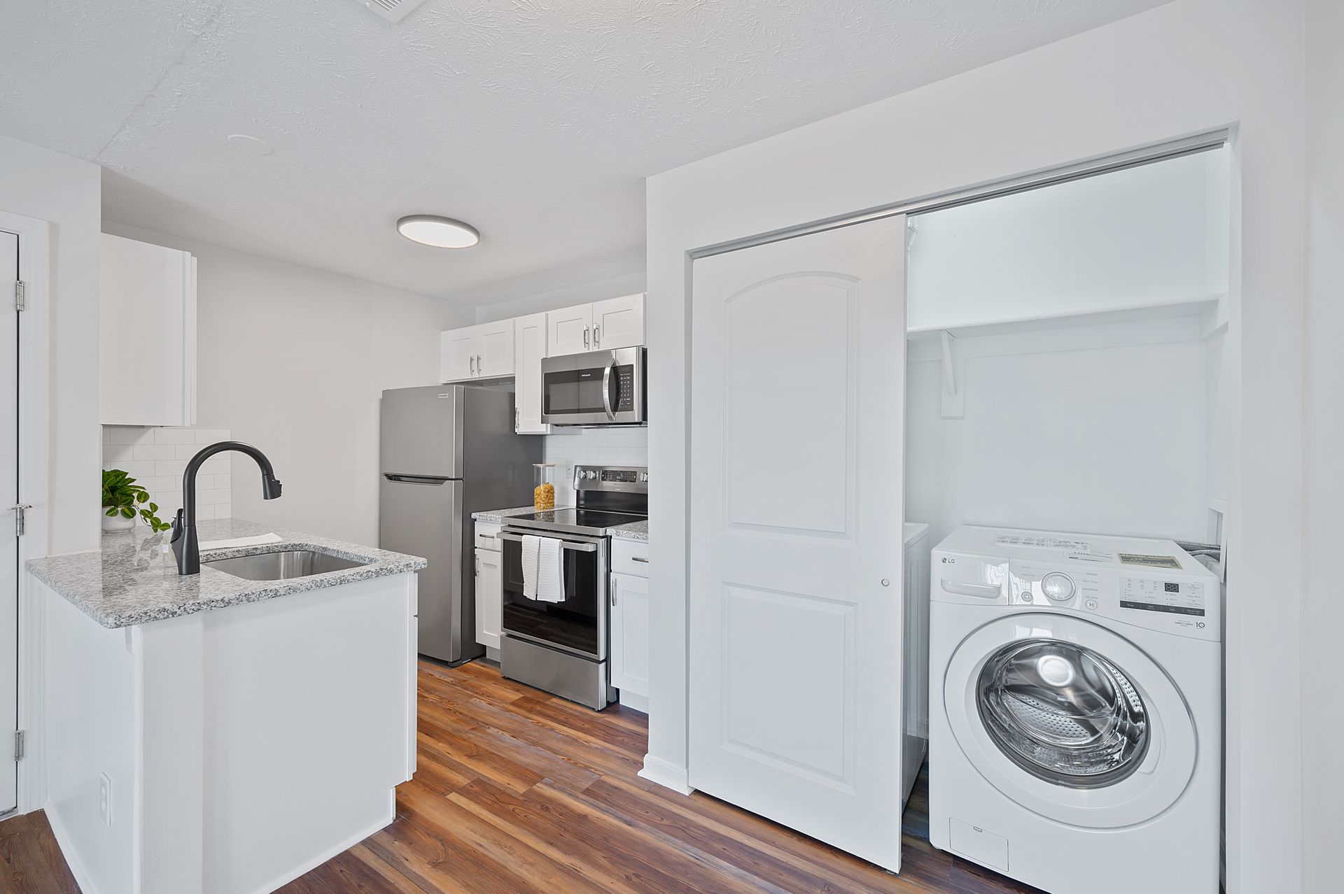 Apartment kitchen with stainless steel appliances and in-unit washer and dryer