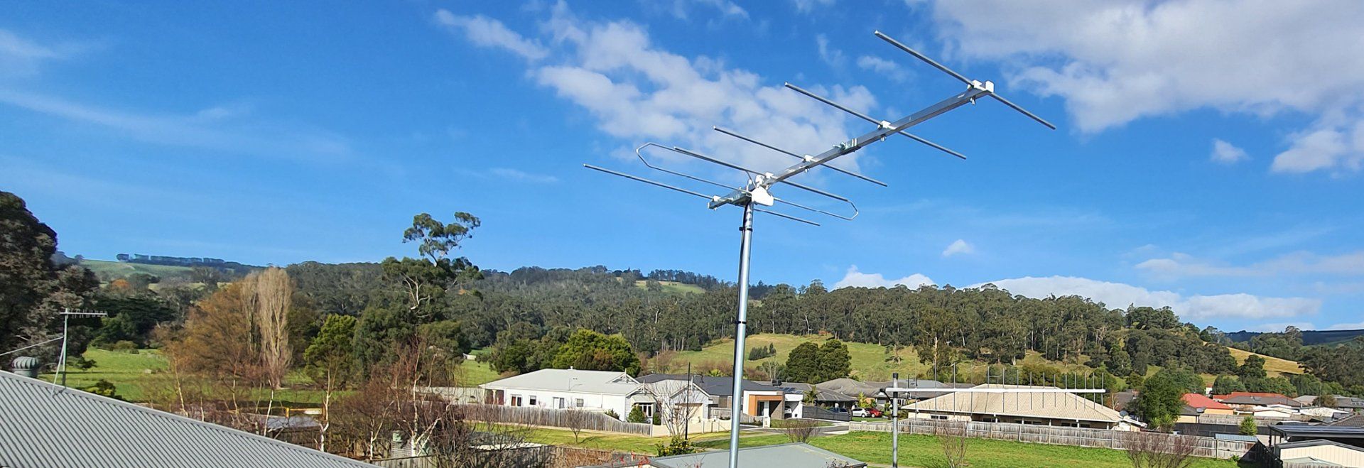 an antenna is sitting on top of a pole in the middle of a field .