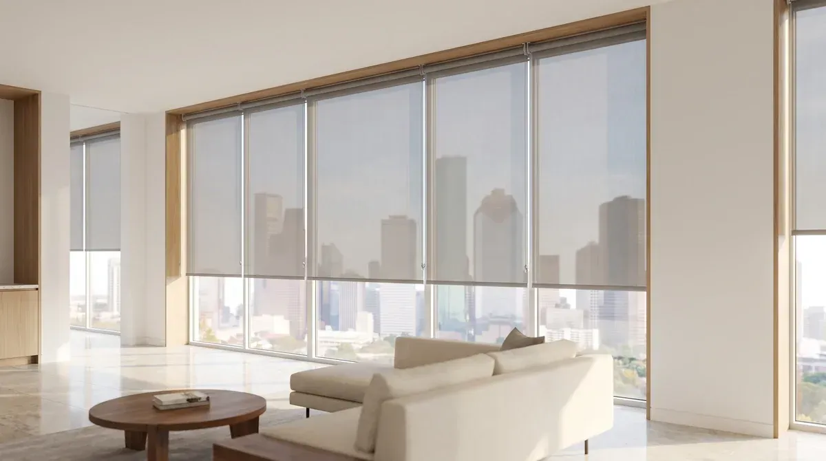Gray solar shades lowered across tall windows of a Houston townhome with the skyline visible beyond