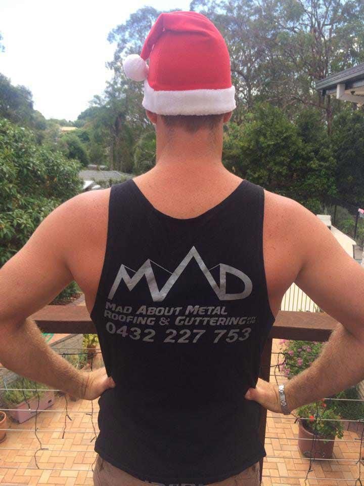 Back Of A Man Wearing Black Mad Shirt With Santa Hat — Mad About Metal Roofing & Guttering PTY LTD in Newcastle, NSW