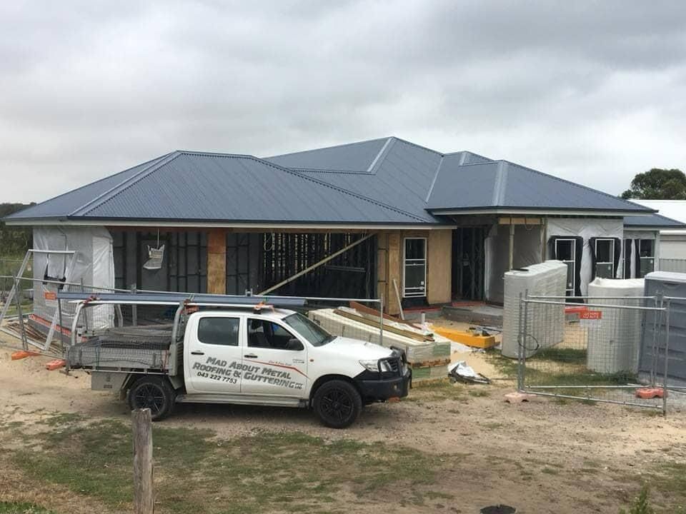 Service Vehicle Outside Of The House Under Construction — Mad About Metal Roofing & Guttering PTY LTD in Newcastle, NSW