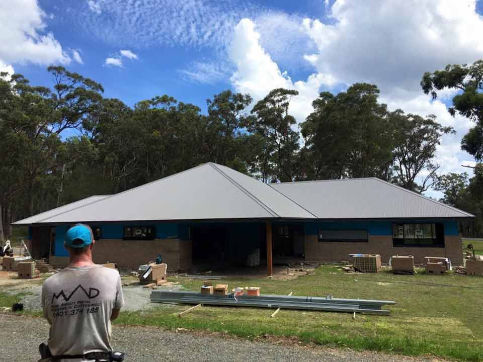 Man Looking At House Construction And New Roof — Mad About Metal Roofing & Guttering PTY LTD in Newcastle, NSW