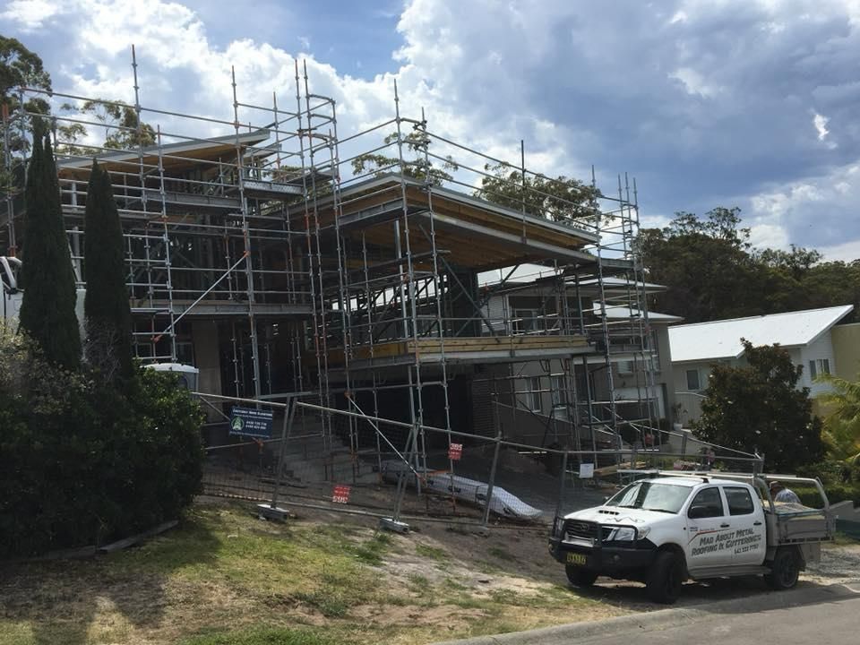 A Truck Is Parked in Front Of A Building Under Construction — Mad About Metal Roofing & Guttering PTY LTD in Newcastle, NSW
