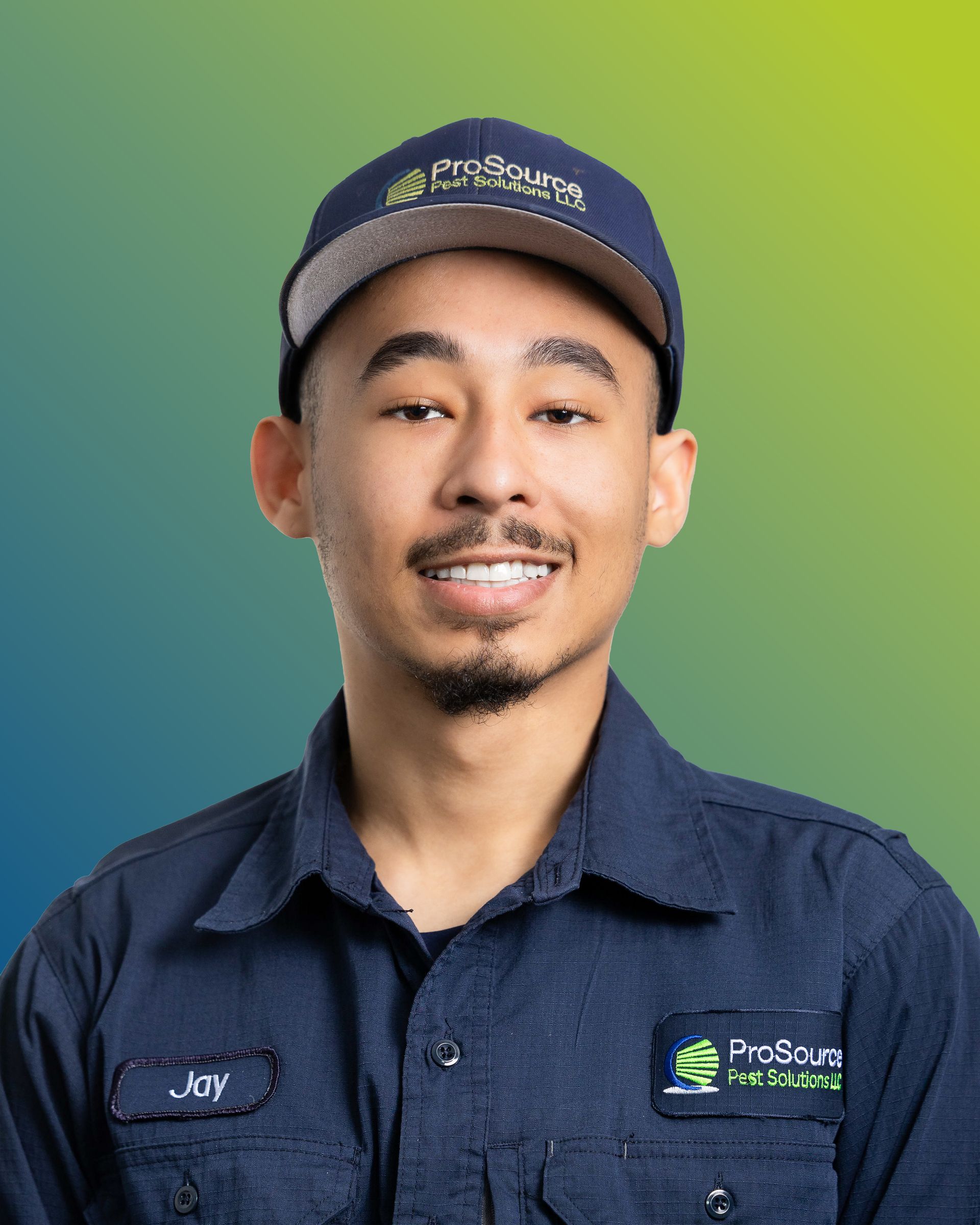 A person wearing a dark blue work shirt and cap with a company logo, smiling against a blue-to-green gradient background.