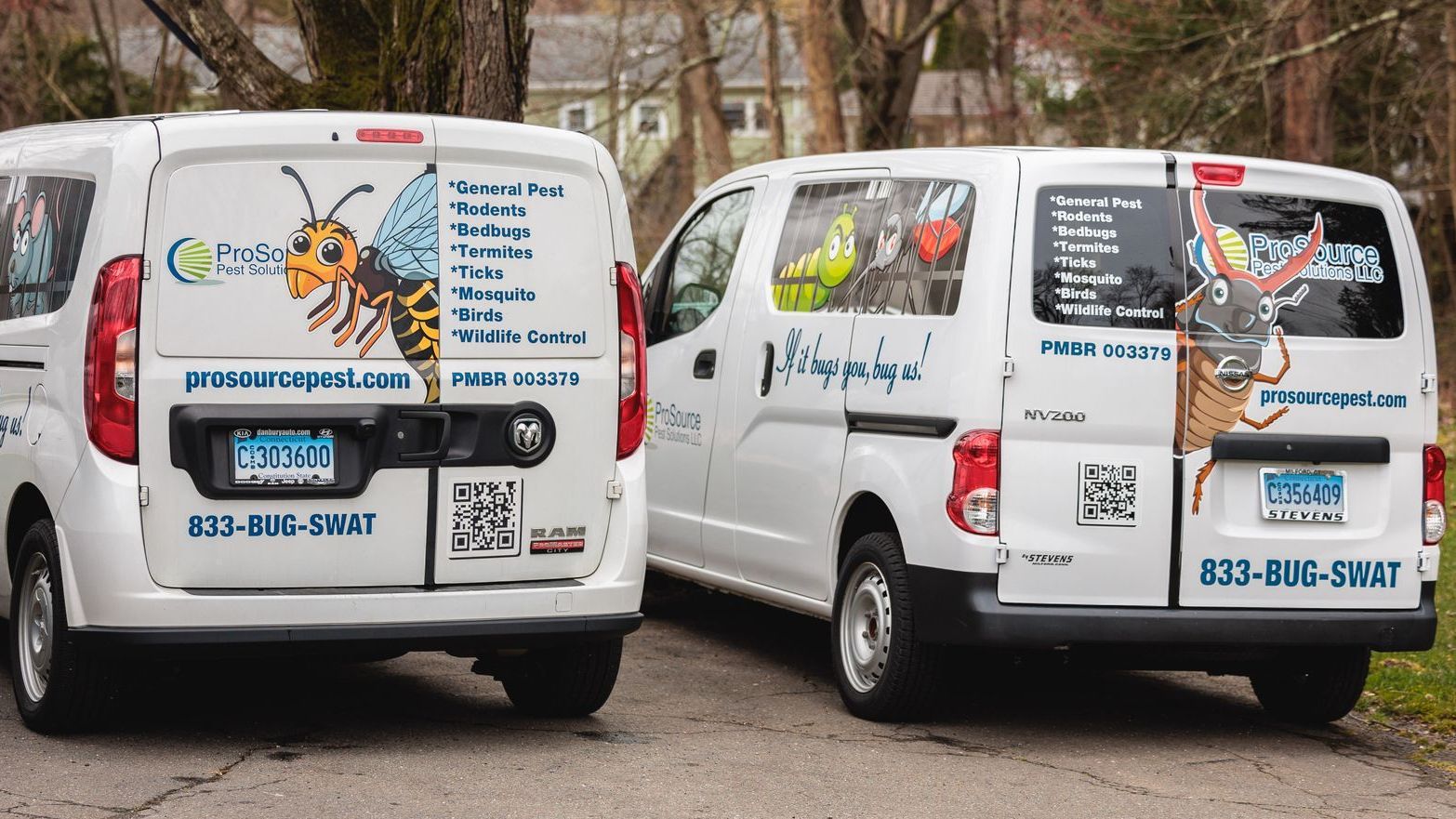 Two white company vans with pest-themed graphics and contact information parked on a road.