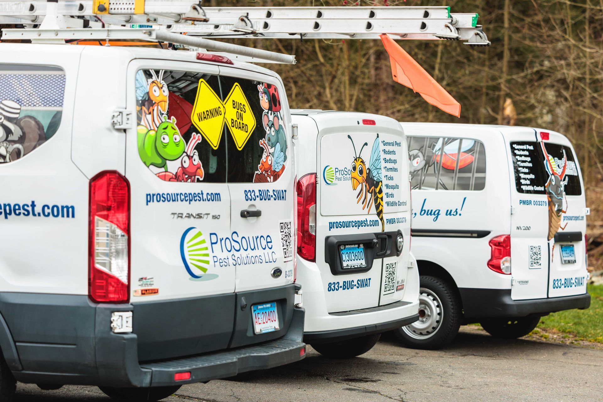 Three white ProSource Pest Solutions vans parked in a row on a gravel lot.