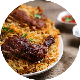 Chicken biryani on a white plate, with a side of sauce.