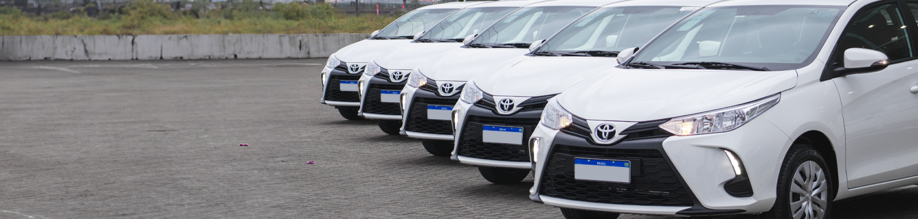 Um grupo de carros está alinhado em uma fileira sobre um fundo branco.