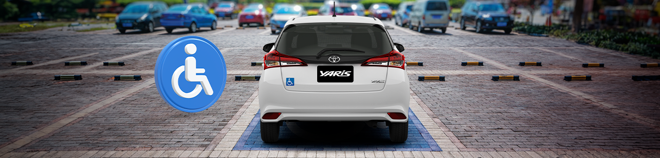 Um SUV branco está estacionado em uma vaga para deficientes.