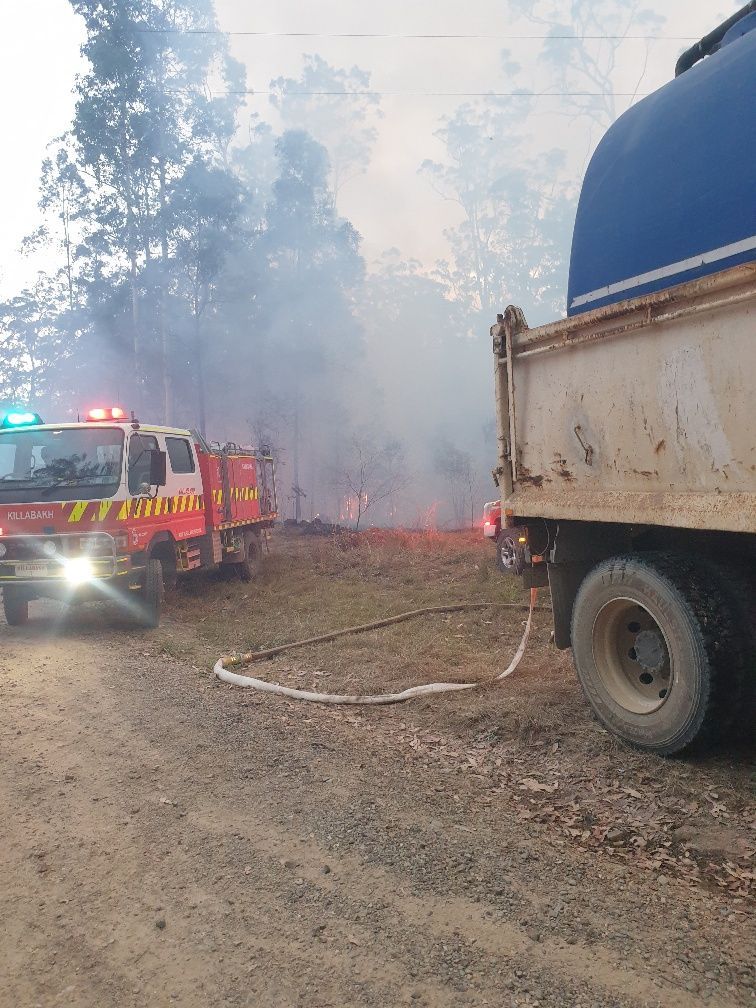 Fire Truck Spraying Water at a Smoky Roadside Brush Fire — Taree & Mid Coast Water Cartage in Hillville, NSW