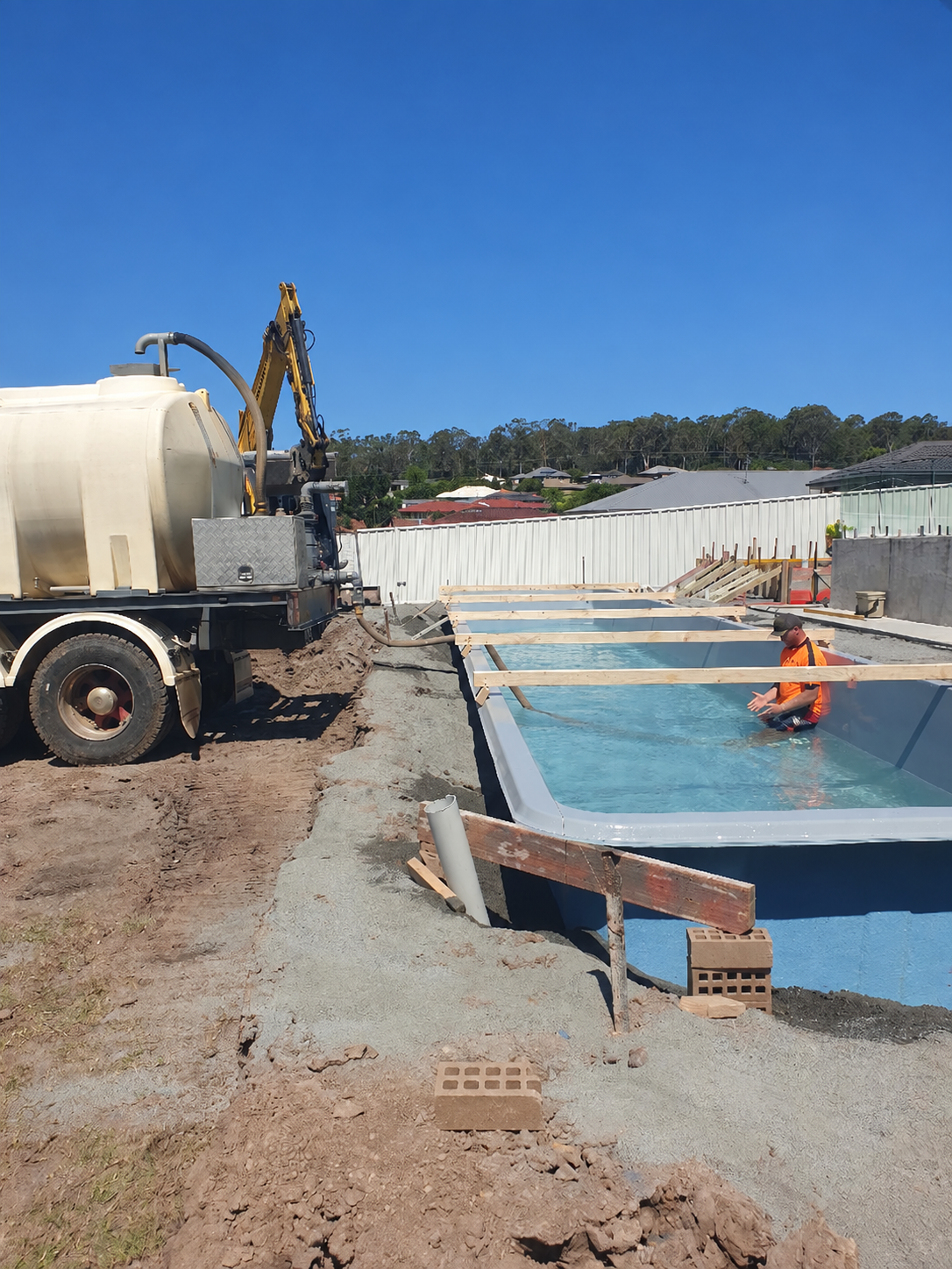 Construction Site With Excavator Beside a Water-filled Pool — Taree & Mid Coast Water Cartage in Hillville, NSW