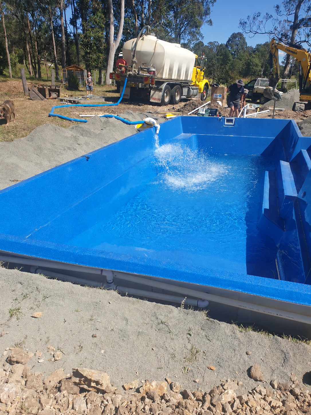 Blue Fiberglass Pool Being Installed at a Construction Site — Taree & Mid Coast Water Cartage in Hillville, NSW