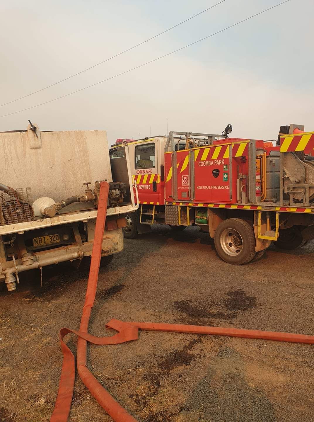 Fire Truck Beside a Burned Vehicle, With Hose Lines on Scorched Ground — Taree & Mid Coast Water Cartage in Hillville, NSW