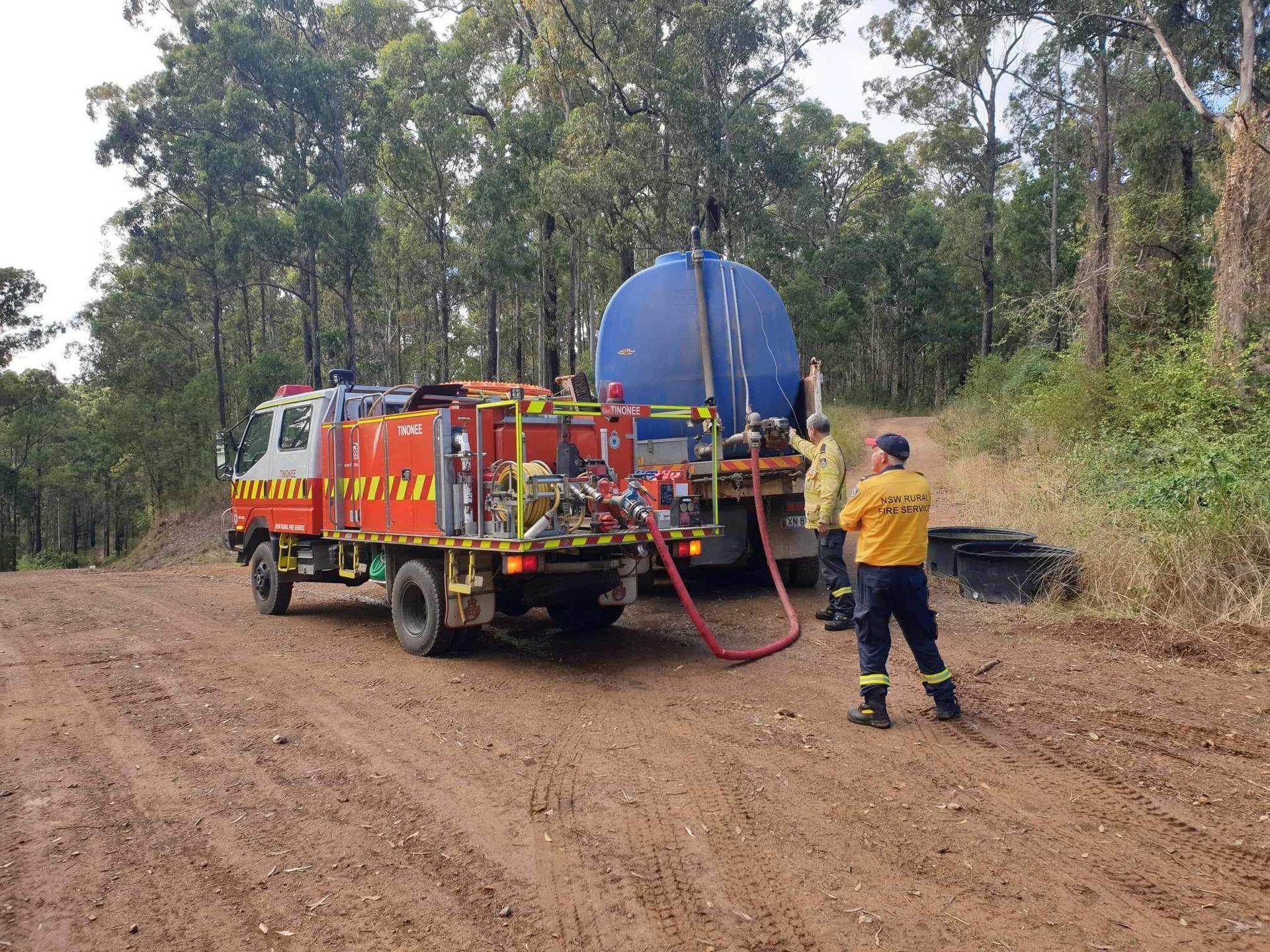 Fire Truck and Firefighter Spraying Water From a Water Tank — Taree & Mid Coast Water Cartage in Nabiac, NSW