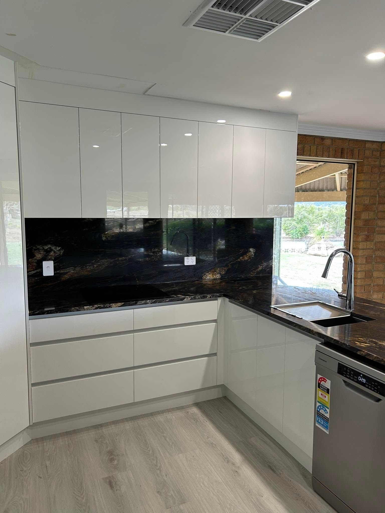 Modern White Kitchen With Black Granite Backsplash and Countertops — Valley Cabinetmakers Pty Ltd In Biloela, QLD 