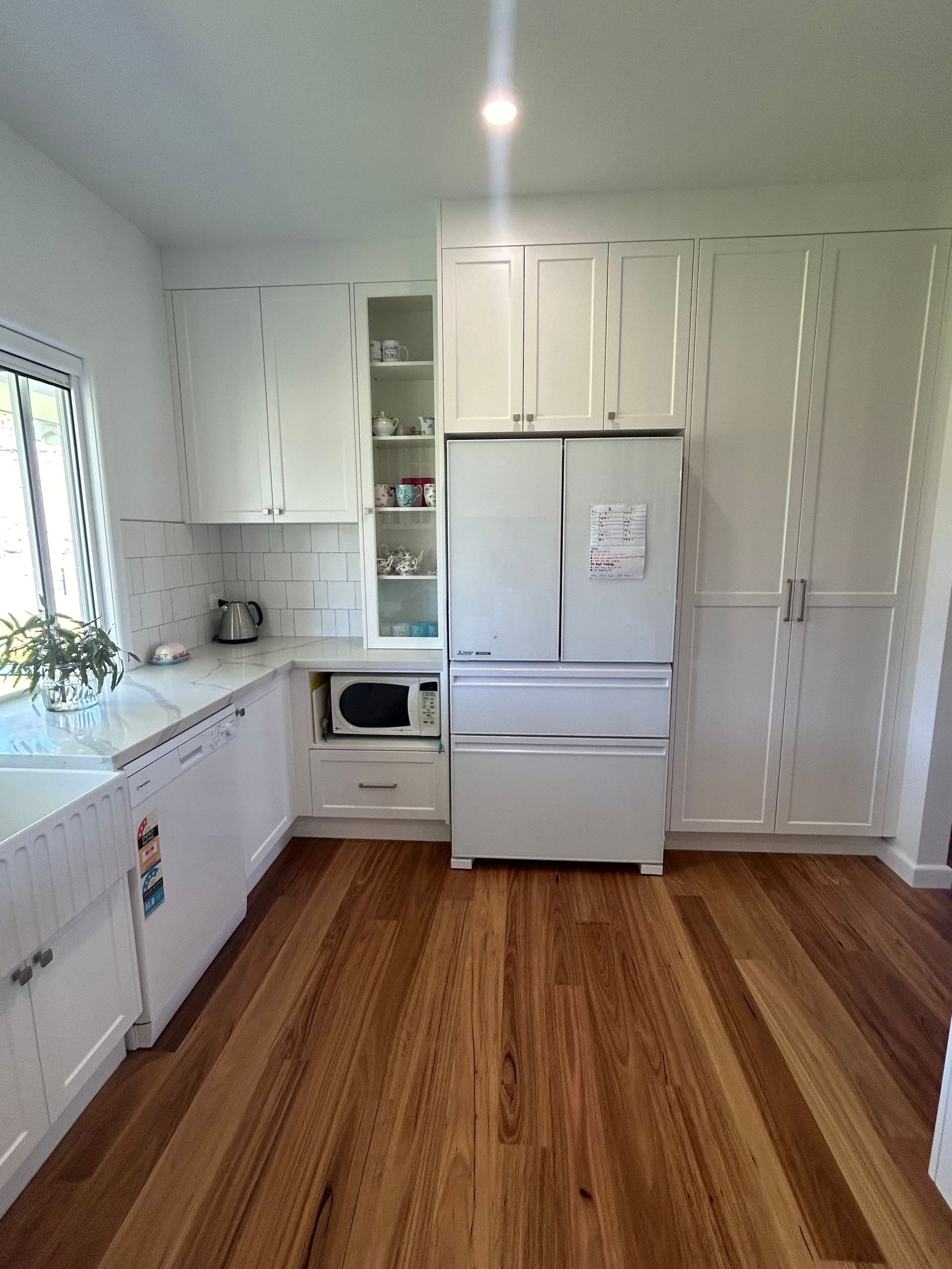 Bright White Kitchen With Wood Floors, White Cabinets, Refrigerator, — Valley Cabinetmakers Pty Ltd In Biloela, QLD