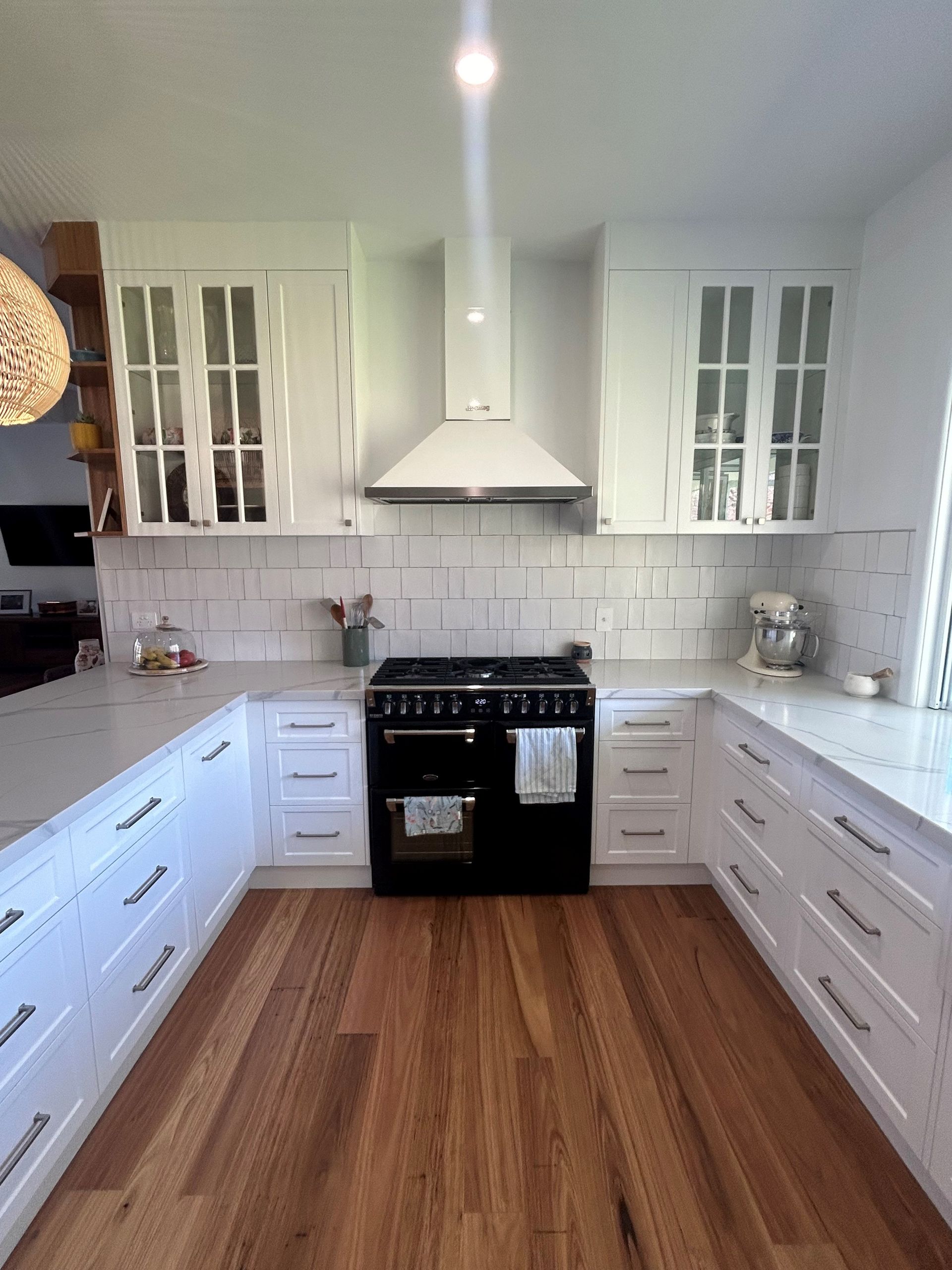 Bright White Kitchen With Black Stove, Long Cabinets, Glass-front Uppers — Valley Cabinetmakers Pty Ltd In Biloela, QLD