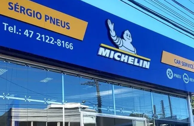 Vitrine da Michelin e Sérgio Pneus com placa azul e janelas de vidro.