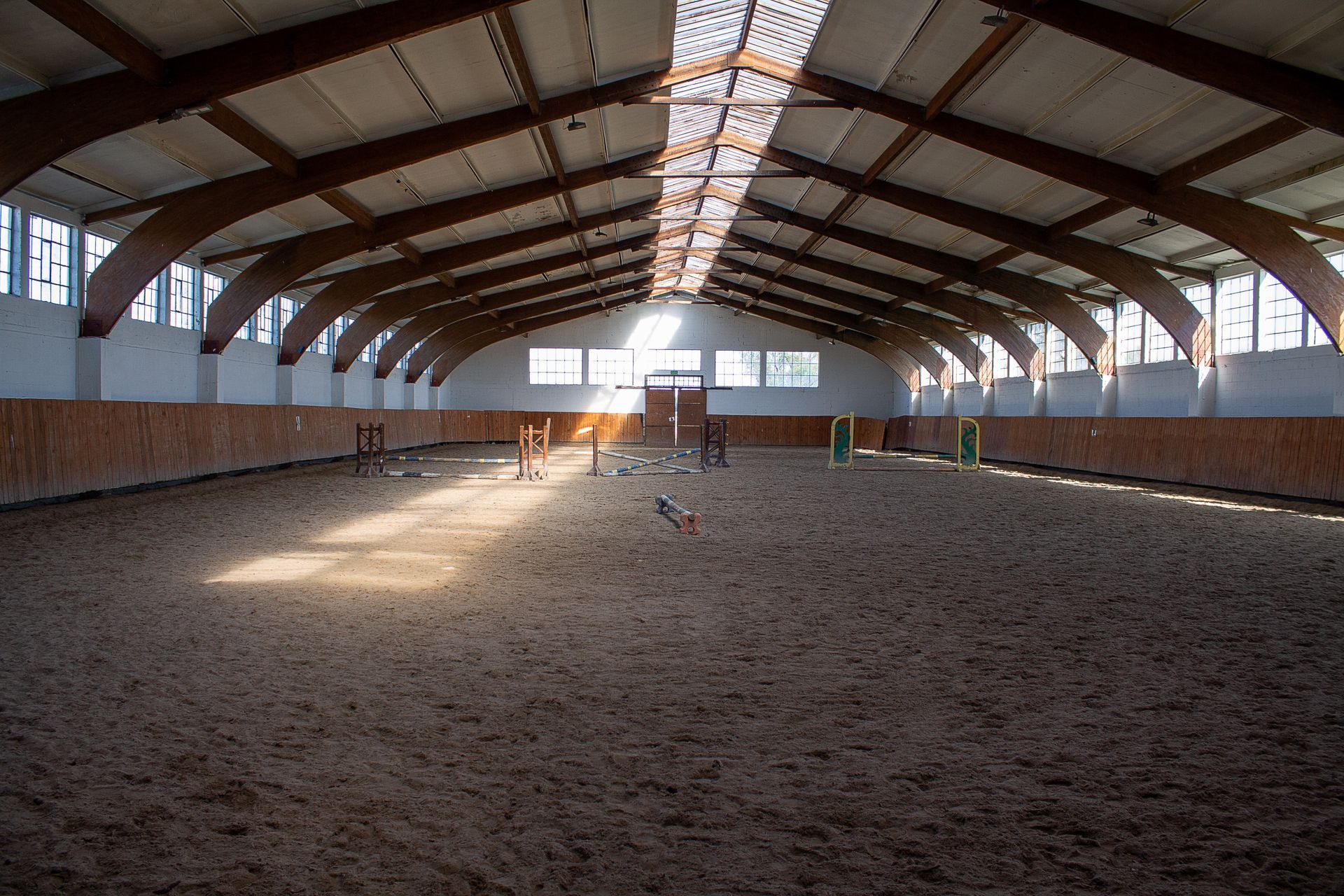 A large empty indoor arena with a wooden roof