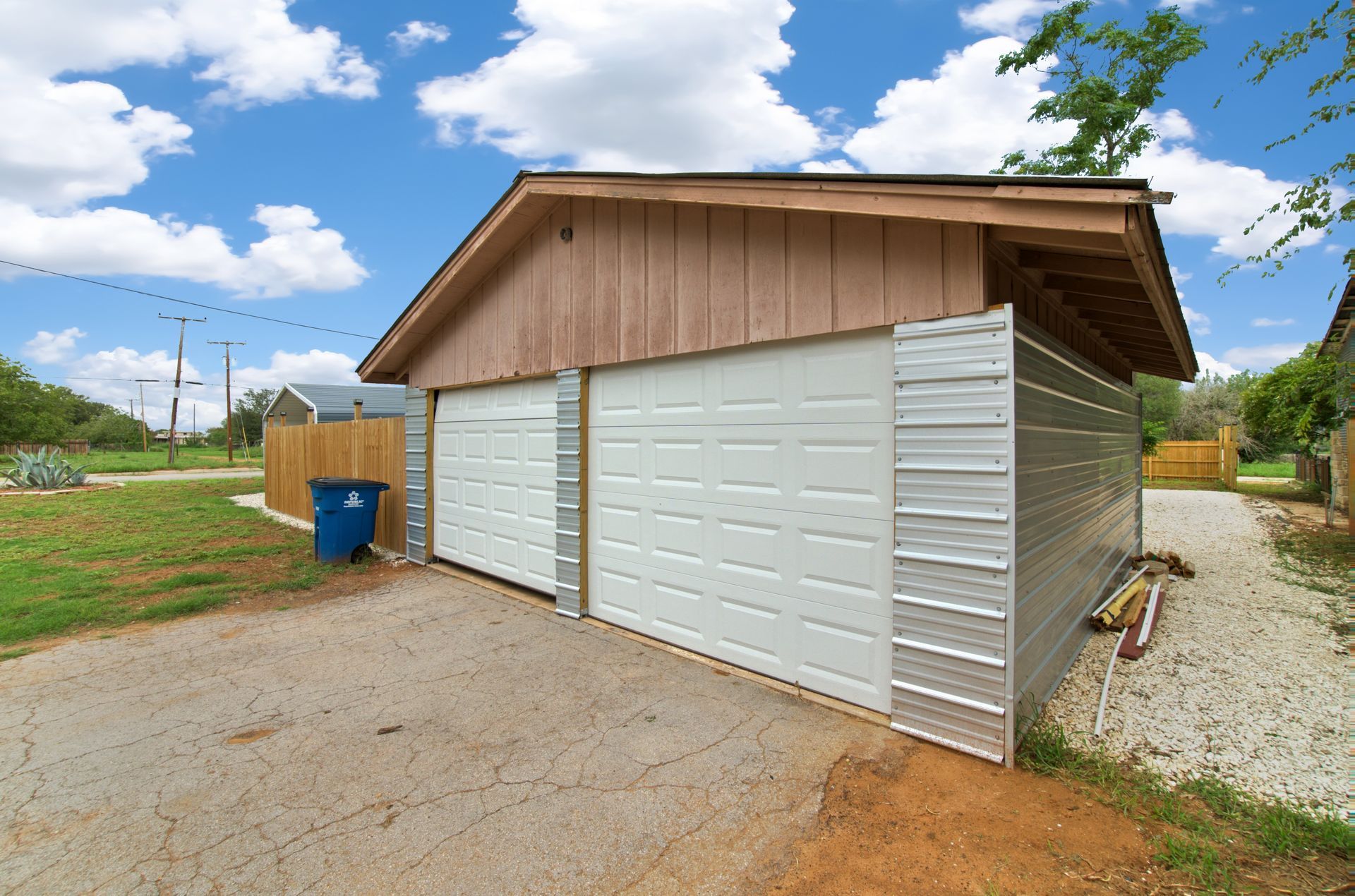 A garage with two white doors and a wooden roof