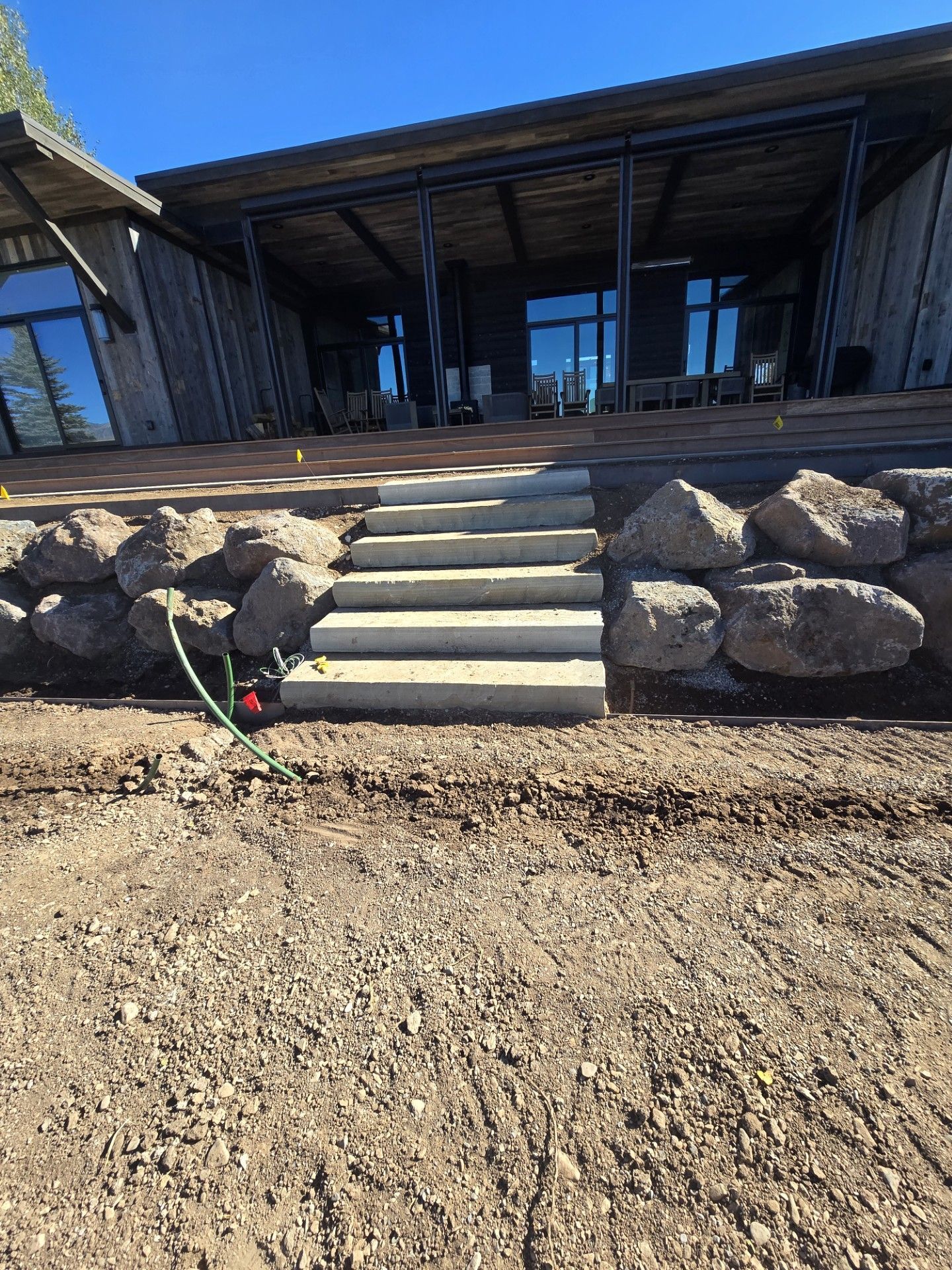 Concrete steps leading to a modern building entrance, retaining wall installed in Jackson WY