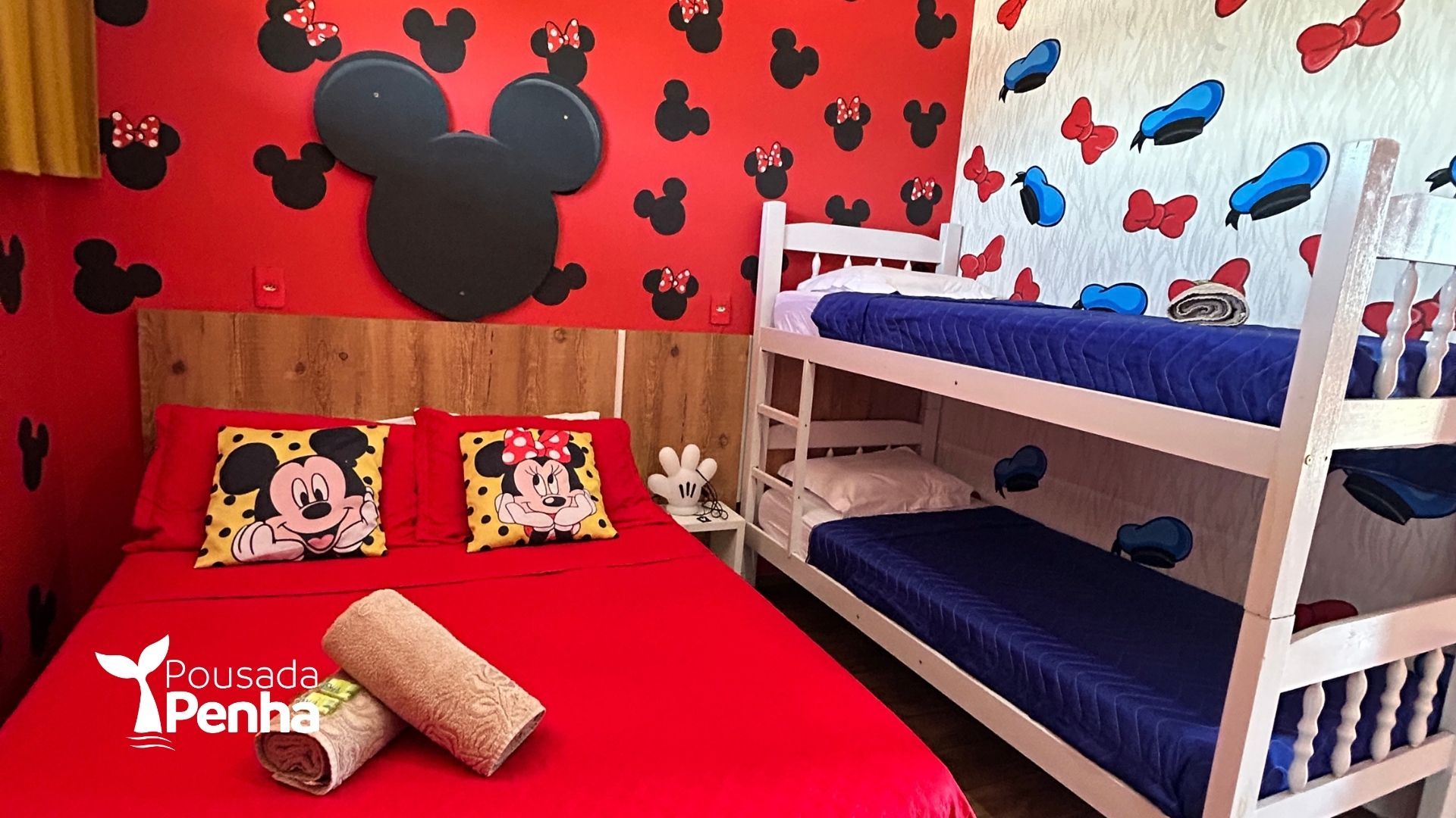 Quarto temático do Mickey Mouse em vermelho e branco, com beliche, colcha vermelha e travesseiros combinando.