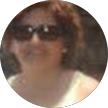 Foto de perfil circular de una persona con gafas de sol y una camiseta clara, sonriendo al aire libre.