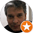 Primer plano del rostro de un hombre con una insignia de estrella naranja en la esquina inferior derecha.