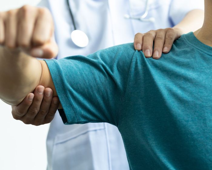 A Man in A Blue Shirt Is Being Examined by A Doctor