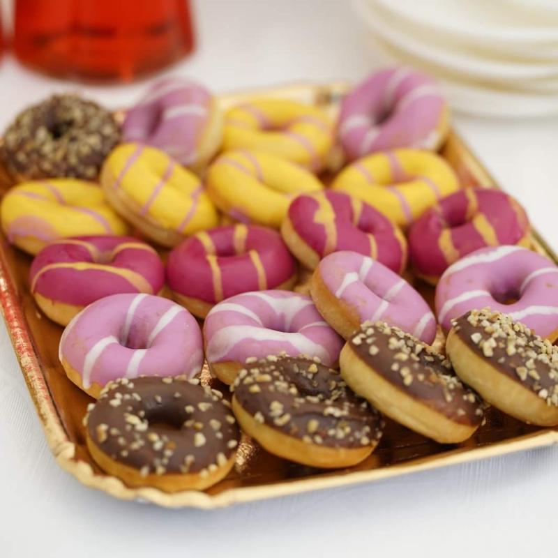 Un vassoio di ciambelle con glassa rosa e gialla