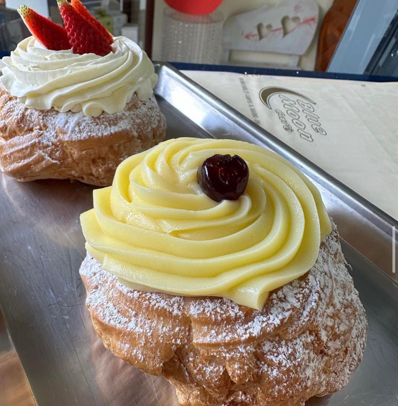 Due pasticcini con glassa gialla e fragole sopra