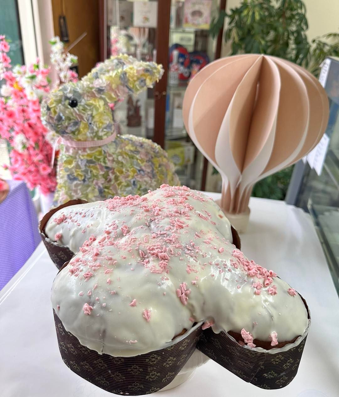 Una torta a forma di coniglio con granelli rosa e una mongolfiera sullo sfondo