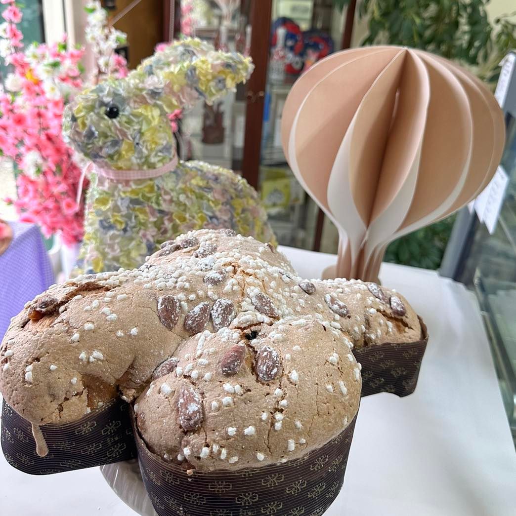 Una torta a forma di farfalla è appoggiata su un tavolo accanto a un coniglietto di peluche.