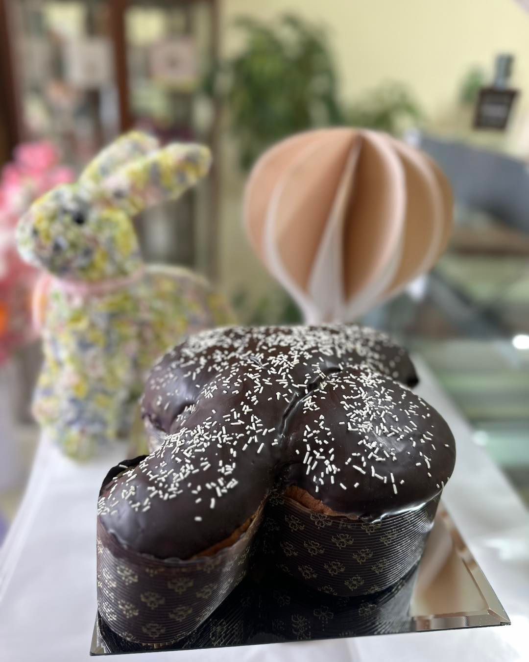 Una campana di cioccolato avvolta nella plastica con un fiocco rosa
