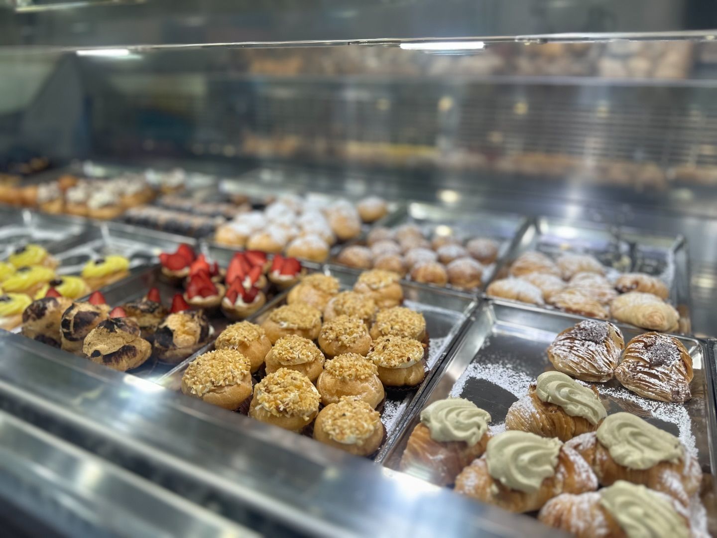 Una varietà di dolci sono esposti in una teca di vetro.