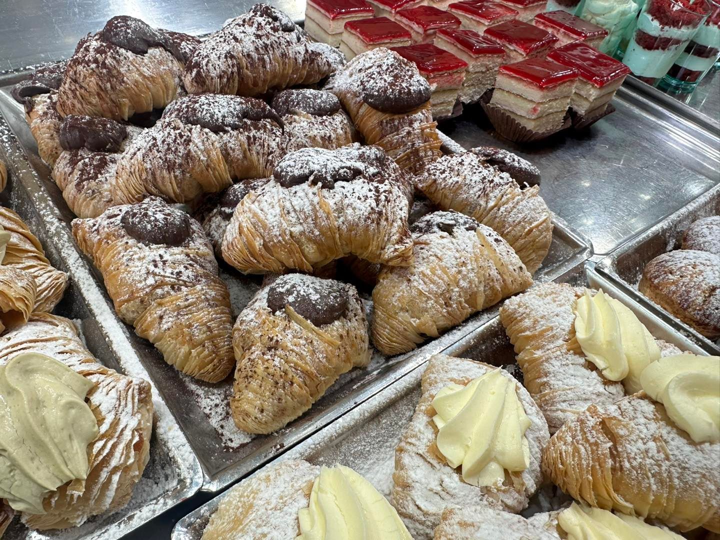 In una panetteria sono esposti vari tipi di dolci e pasticcini.