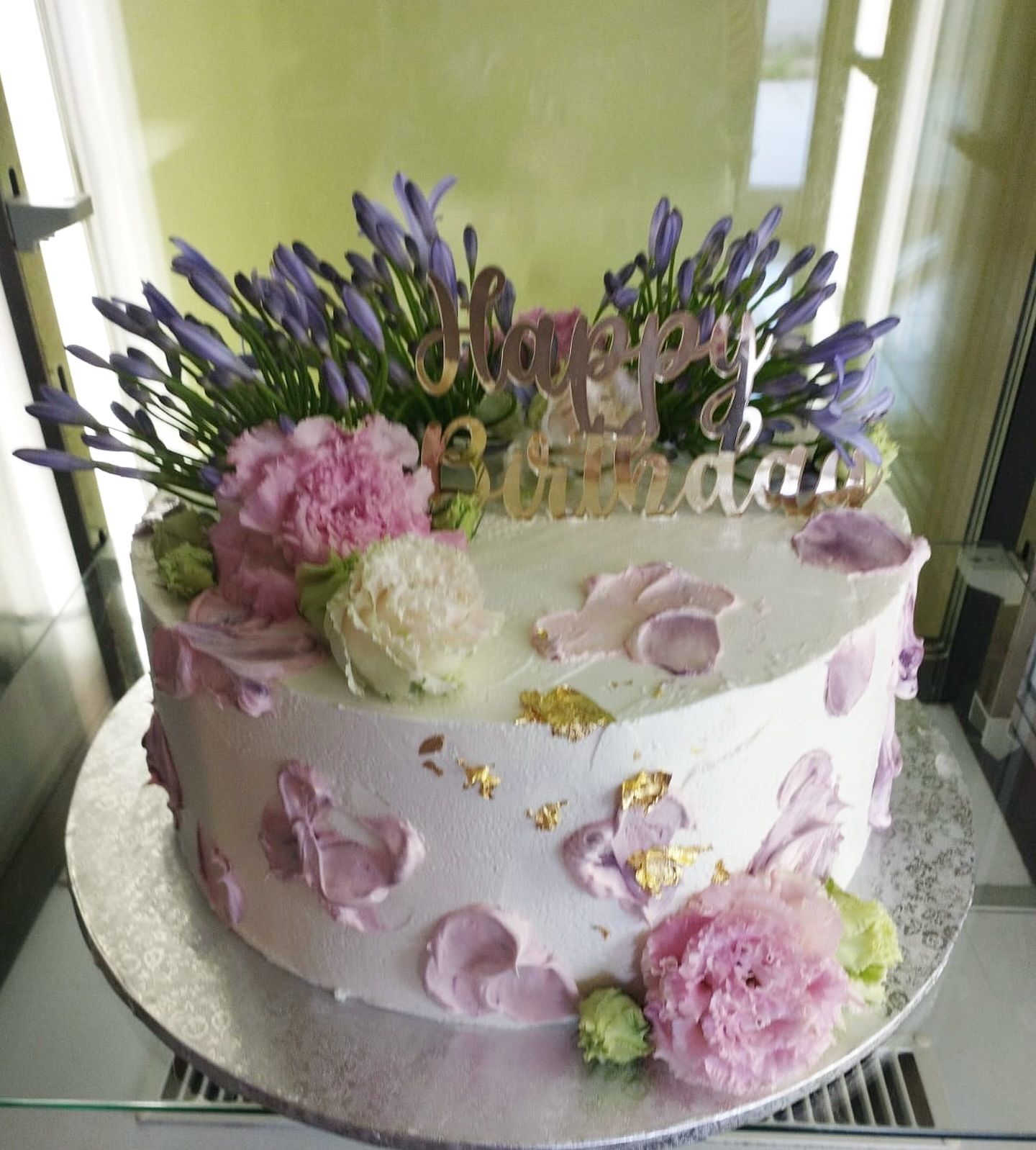Una torta di compleanno con fiori rosa e le parole buon compleanno
