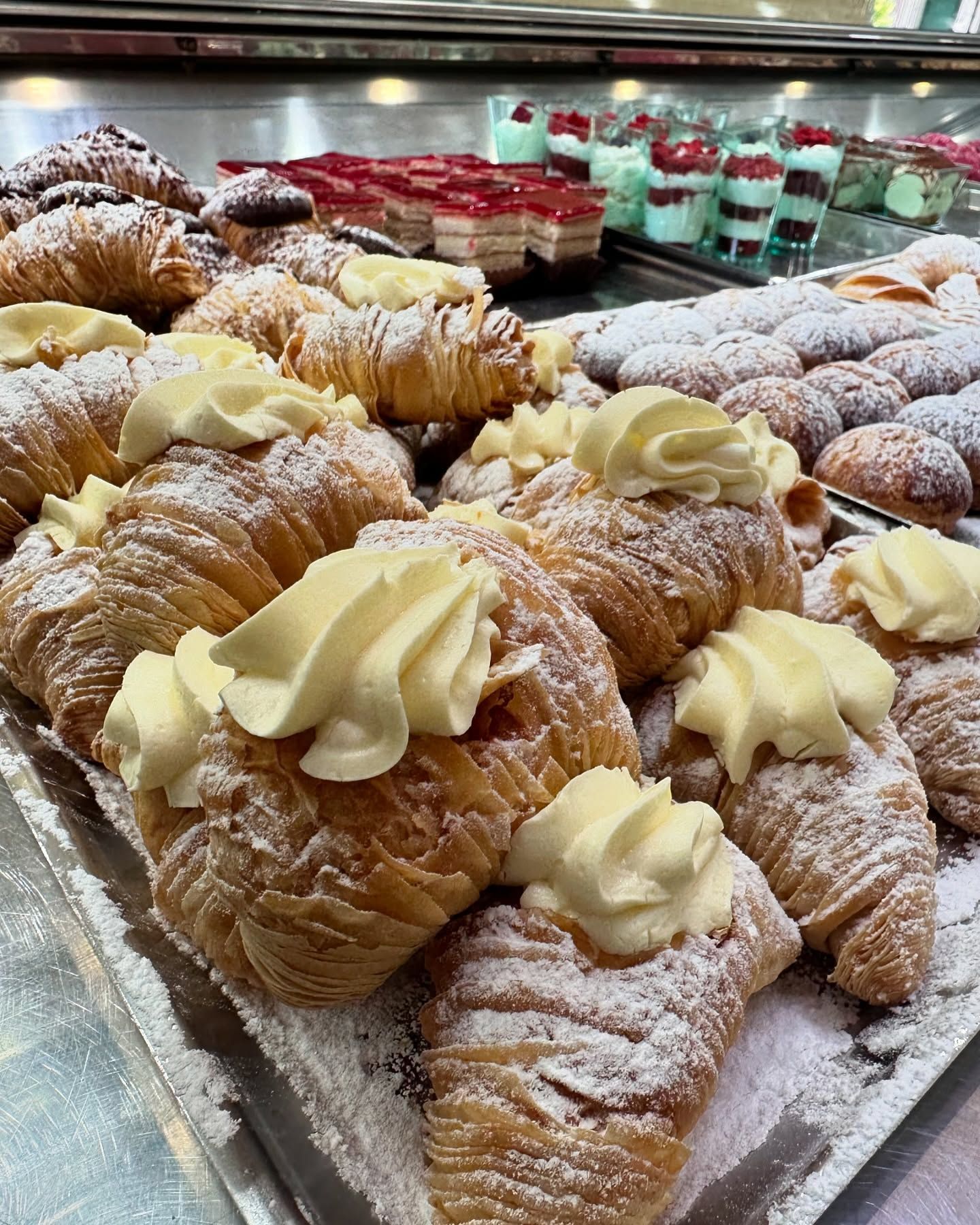 Un vassoio di pasticcini con panna montata e zucchero a velo sopra.