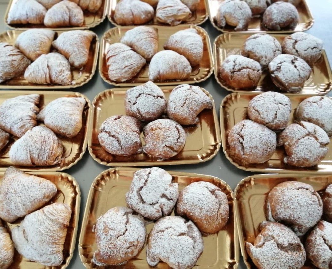 Un mucchio di vassoi di cibo con sopra lo zucchero a velo