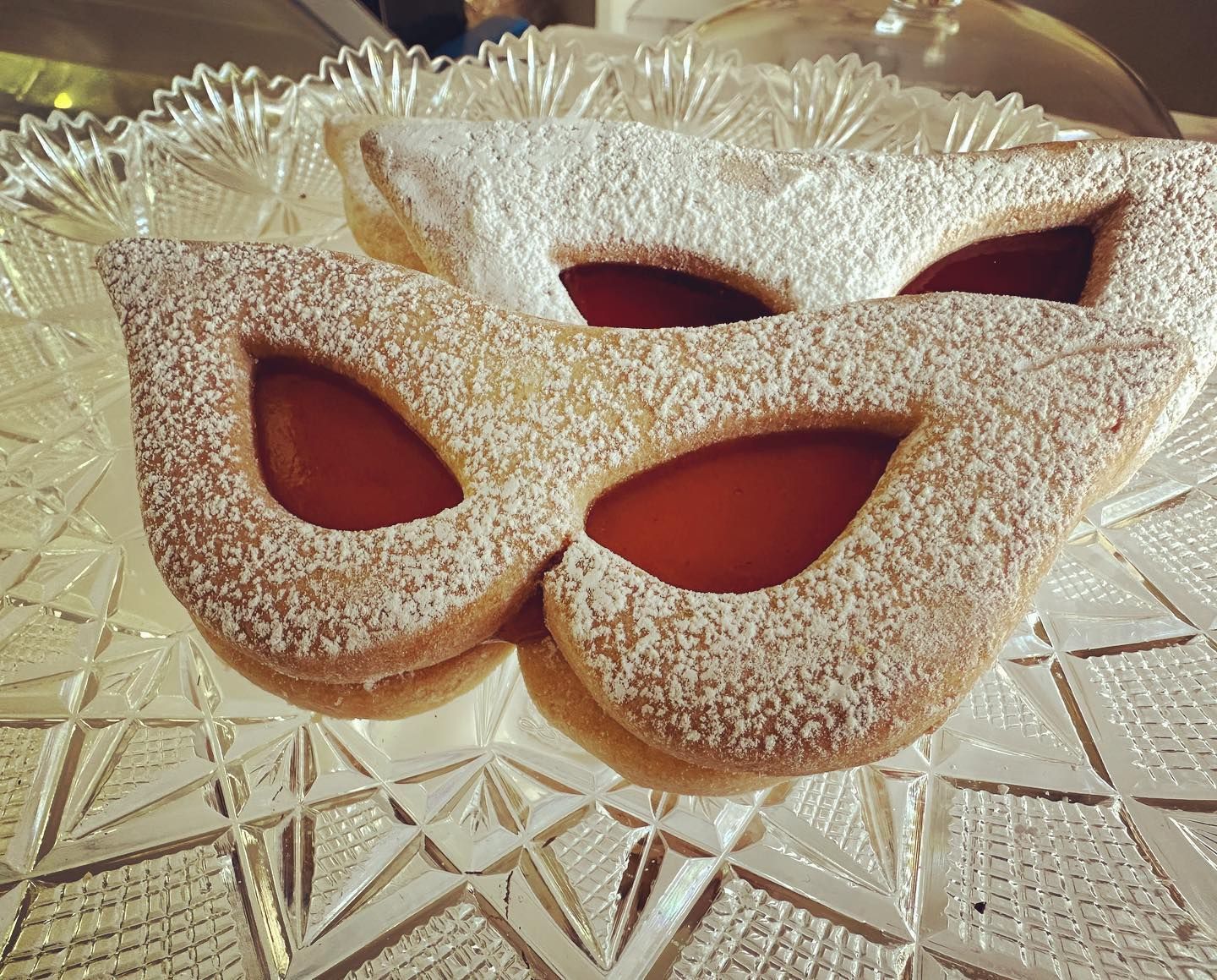 Un biscotto a forma di maschera con zucchero a velo su un piatto di vetro