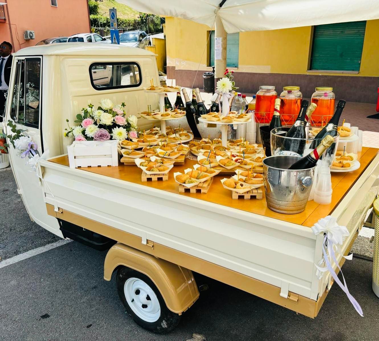 Un camion bianco con un tavolo di legno pieno di cibo e bevande