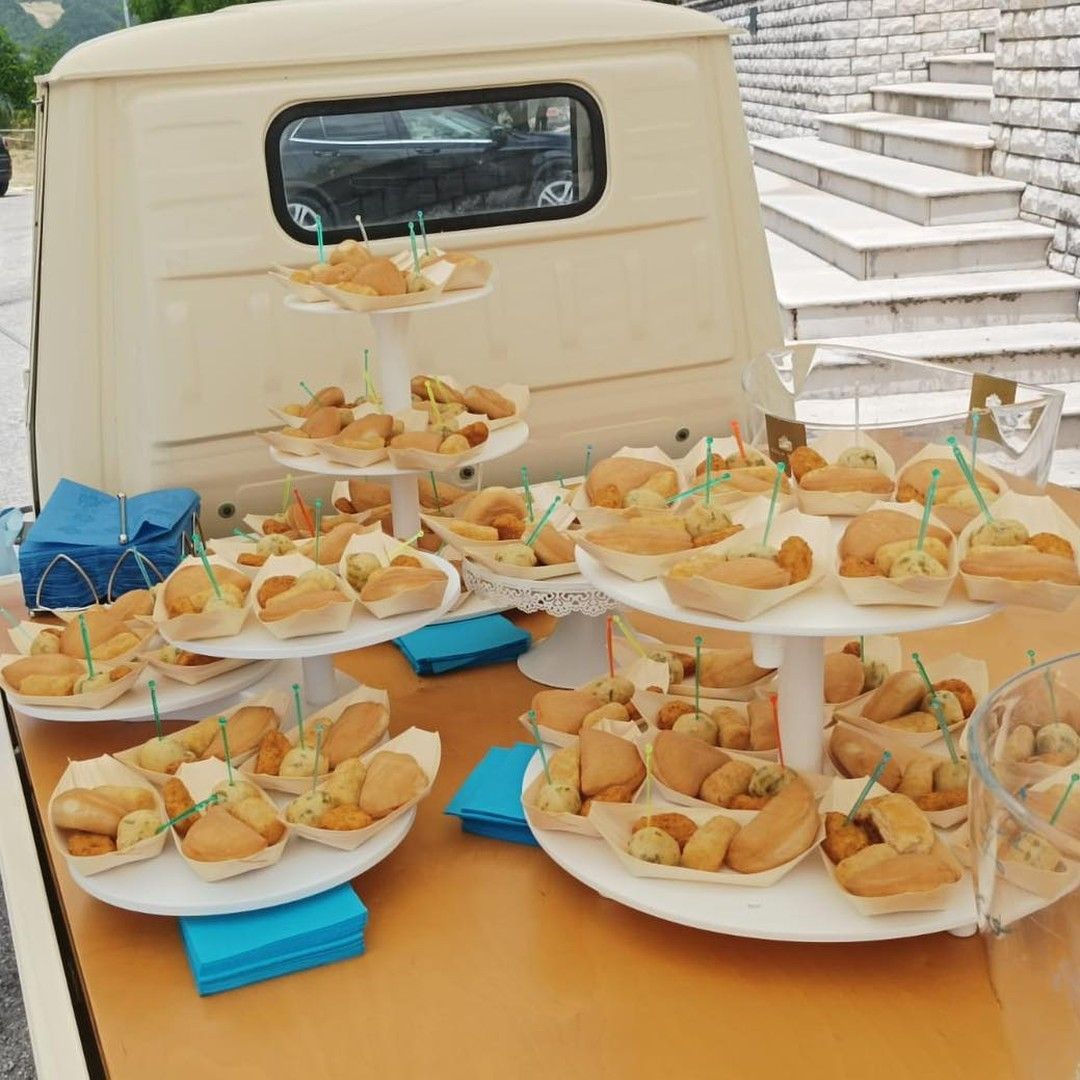 Diversi vassoi di cibo sono su un tavolo davanti a un furgone