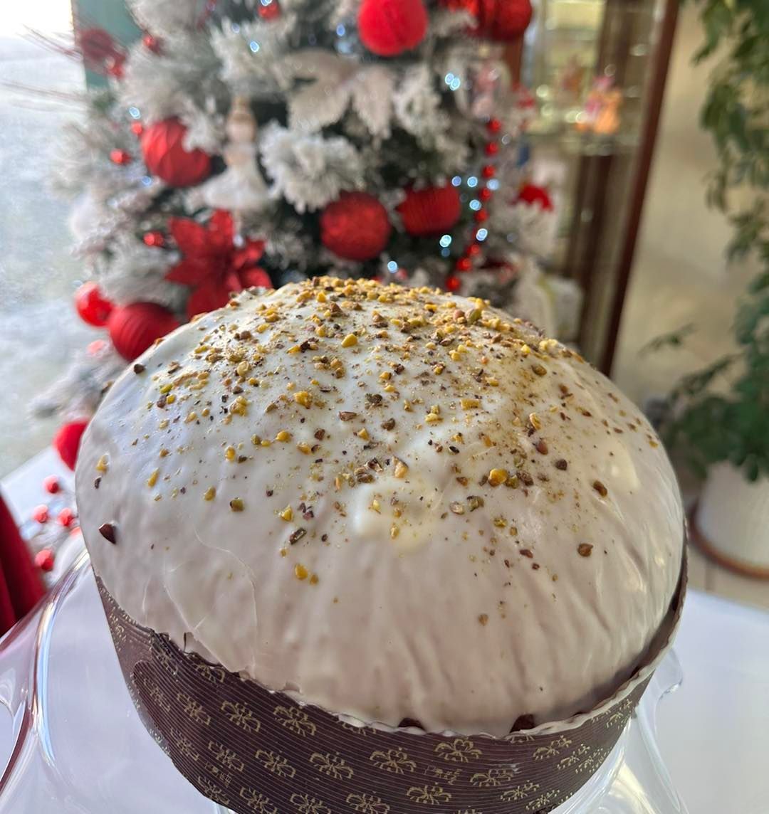 Un primo piano di una torta con un albero di Natale sullo sfondo